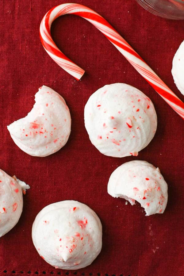 christmas meringues on a napkin with a candy cane.