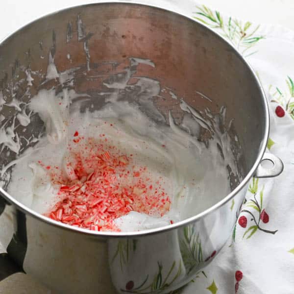 folding candy canes into christmas meringue mixture.
