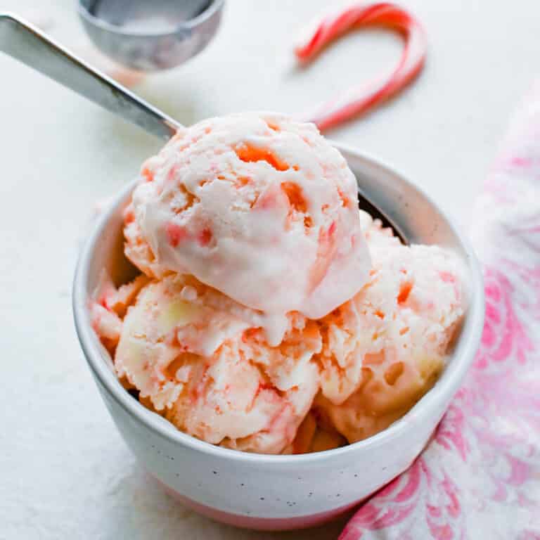 Three scoops of peppermint stick ice cream with a candy cane.