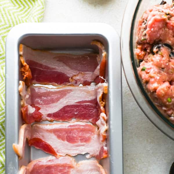 lining a terrine pan with bacon.