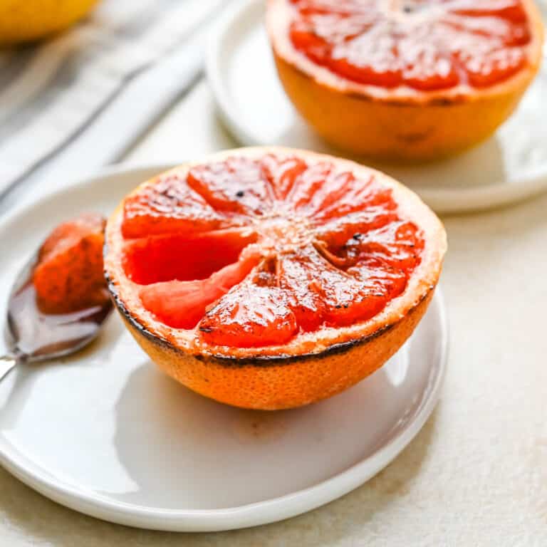 Broiled grapefruit halves on a plate.