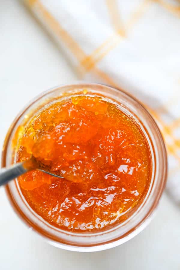 Dipping a spoon into the marmalade jar.