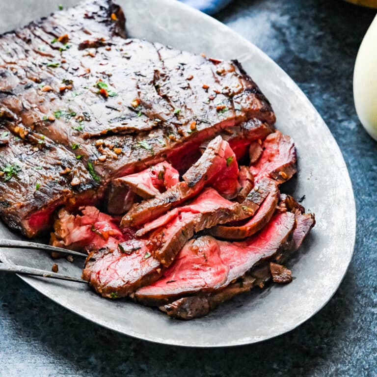 Grilled flank steak on a platter.
