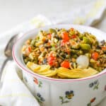A bowl of olive salad with artichokes and pearl onions.