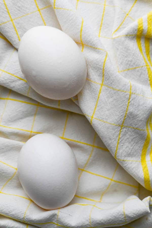 two eggs on a dish towel.