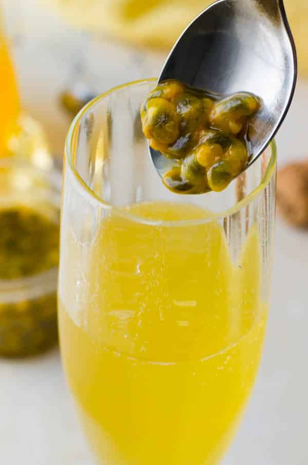 Adding passion fruit seeds to the easy bellini recipe.