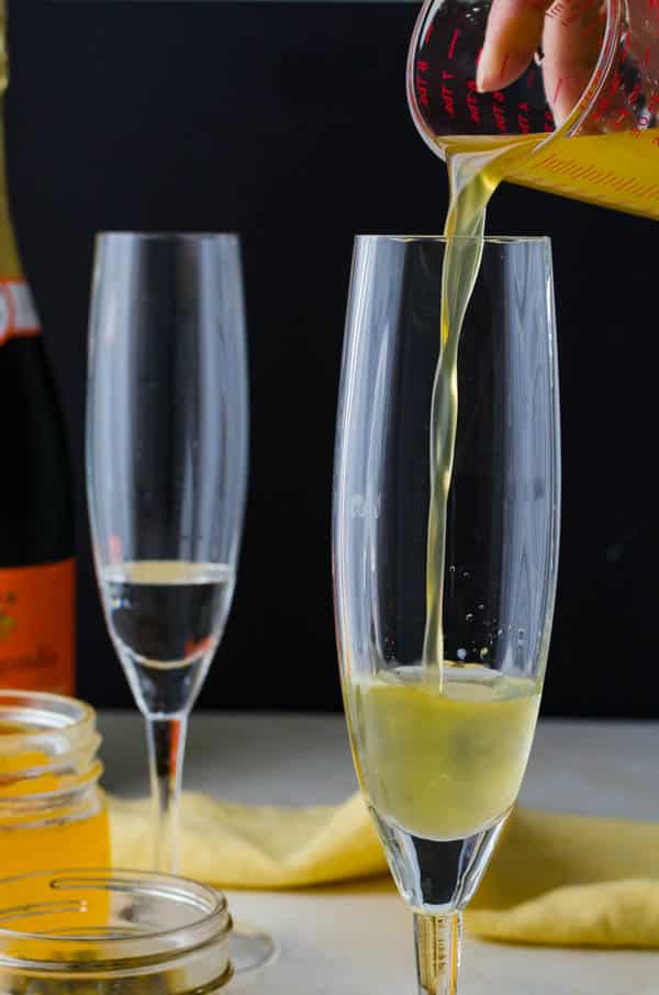 adding infused syrup to a champagne flute.