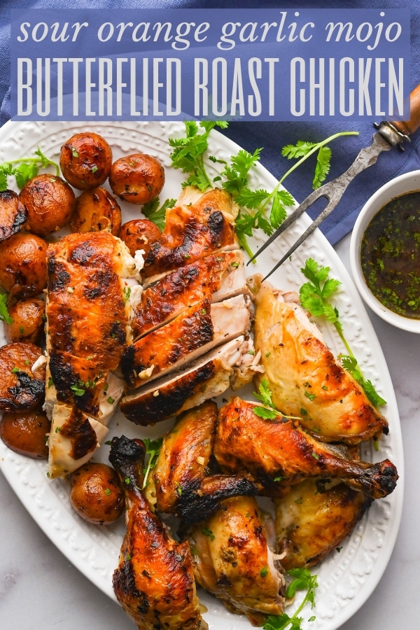 Sour Orange Juice Garlic Mojo Butterflied Roast Chicken is tender and flavorful. Cooked in a cast iron skillet it's ready to eat in about an hour. #spatchcockchicken #mojochicken
