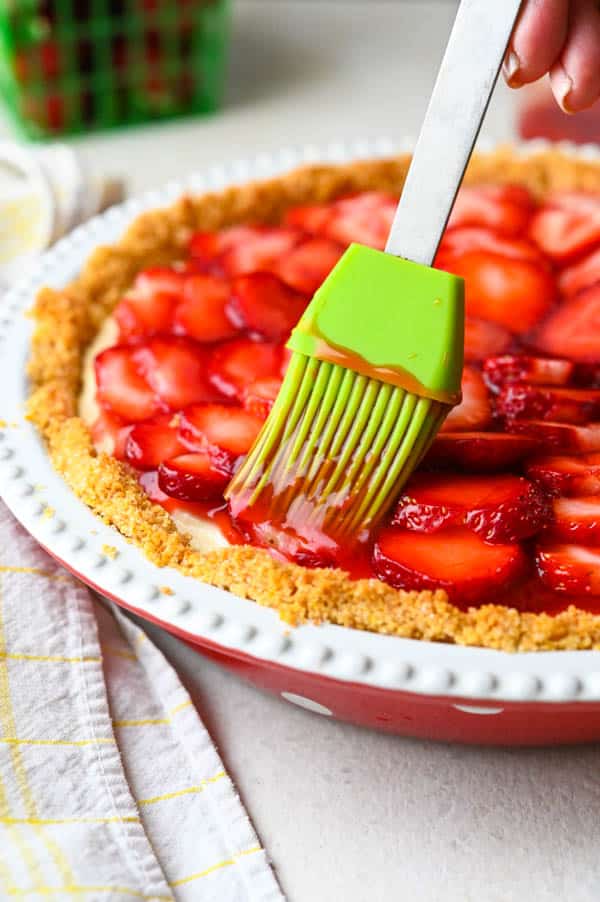 brushing glaze on strawberry ricotta tart.