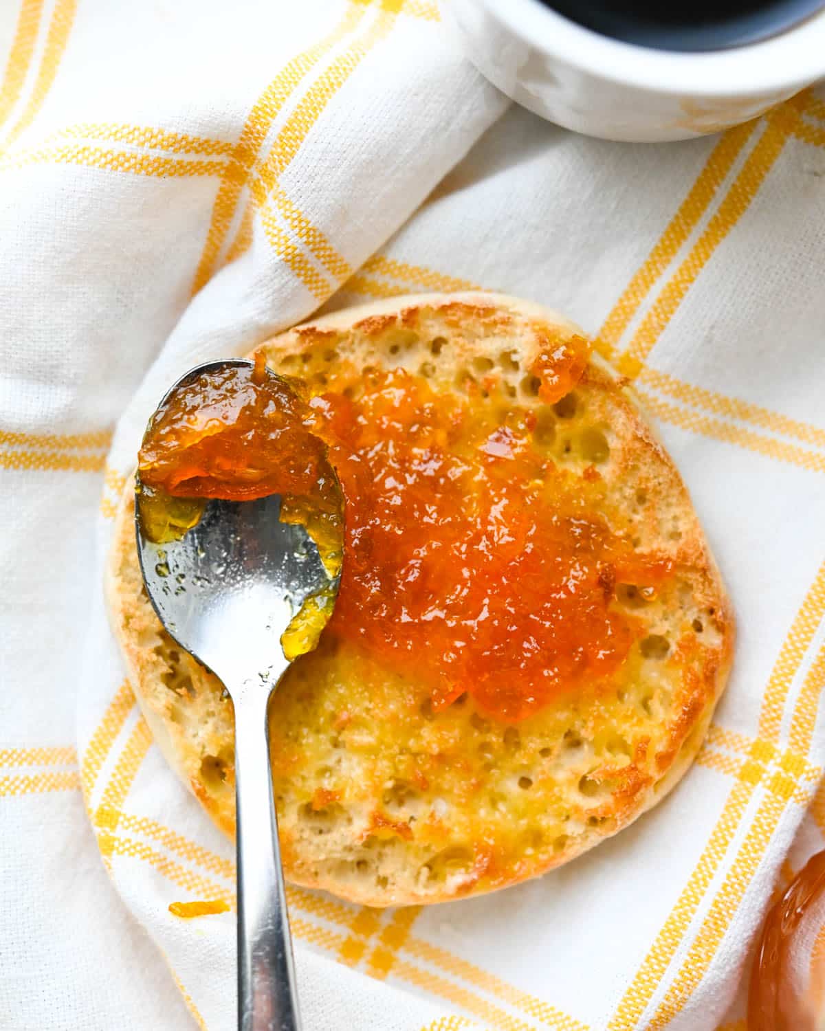 I am spreading calamansi lime marmalade on an English muffin.