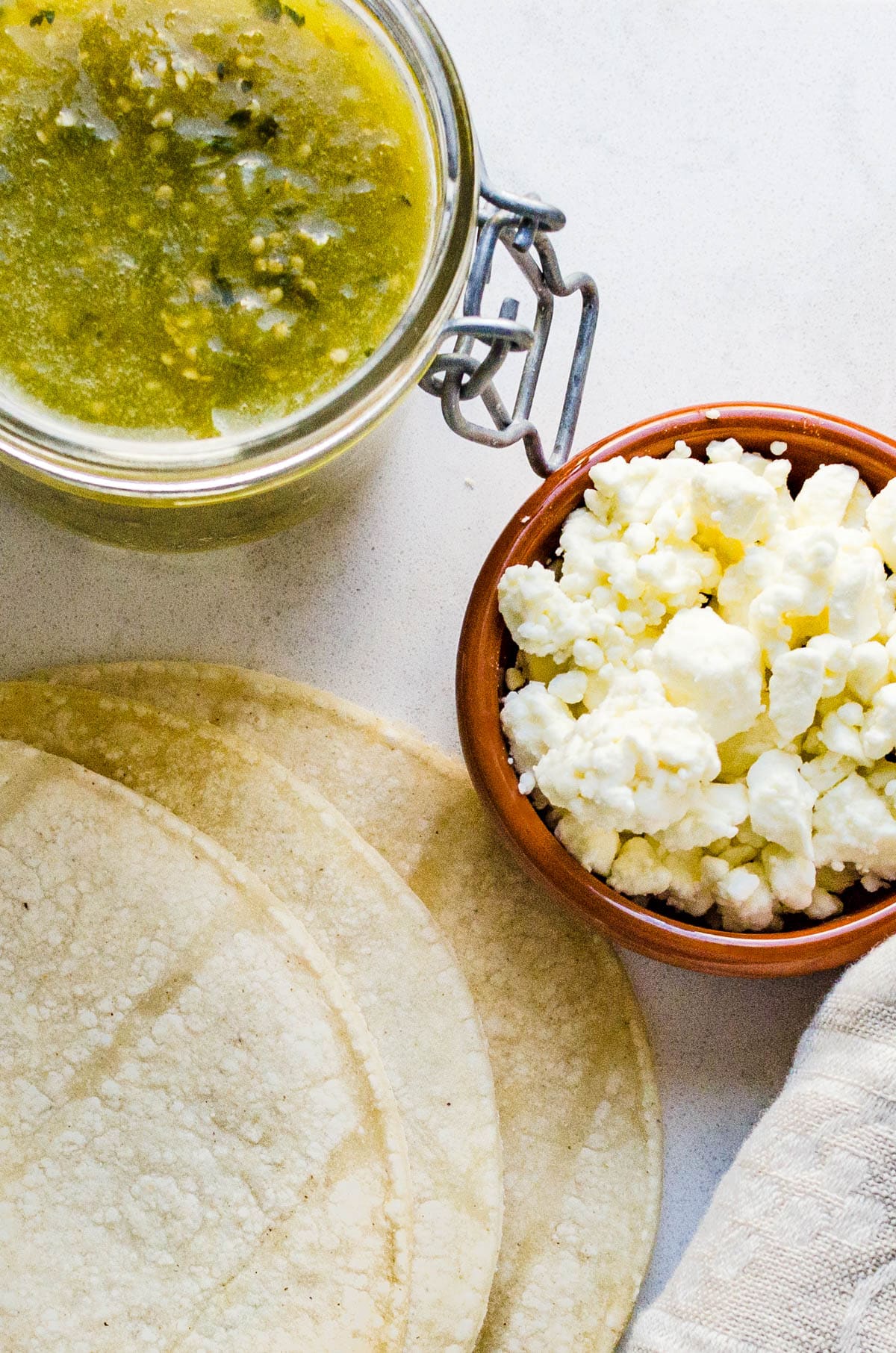 corn tortillas, salsa verde and crumbled cotija cheese for Mexican chalupas recipe.