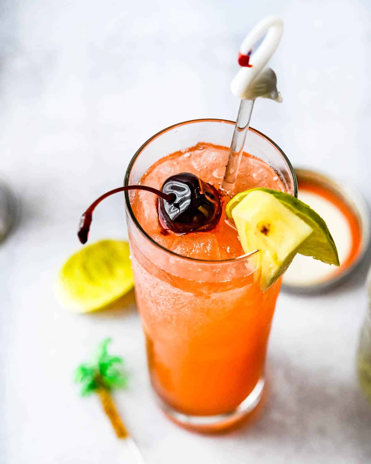 A frosty planters punch with a cherry and pineapple garnish.