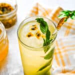 A glass of passion fruit mojito with fresh mint.