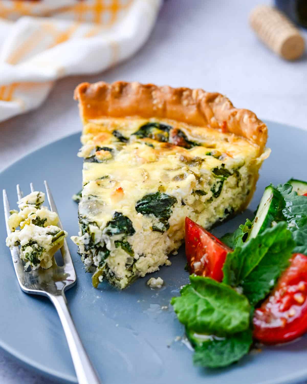 Serving a slice of quiche florentine with a side salad.