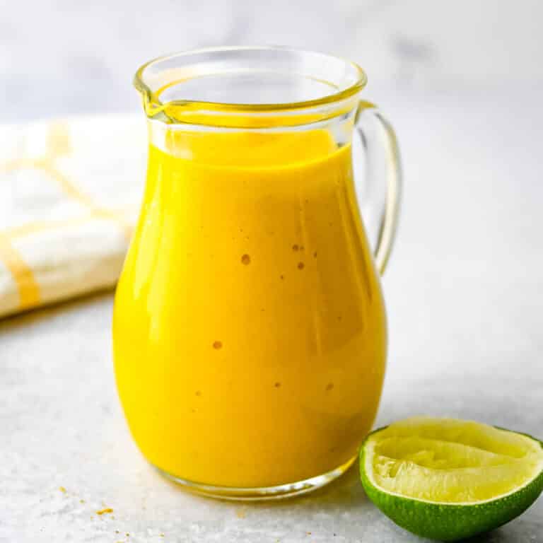 a jar of curried mango dressing with lime juice.