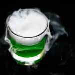 A serving of swamp gasses green Halloween punch with dry ice.