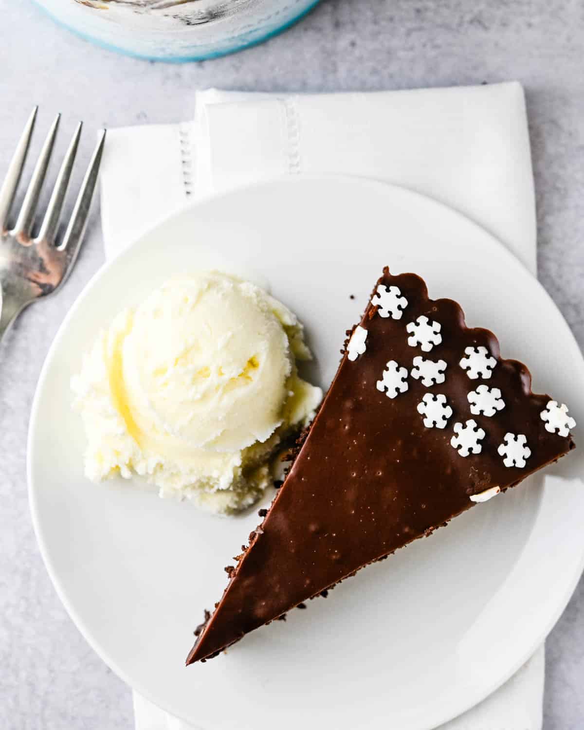 A slice of death by chocolate fudge tart with a scoop of ice cream.