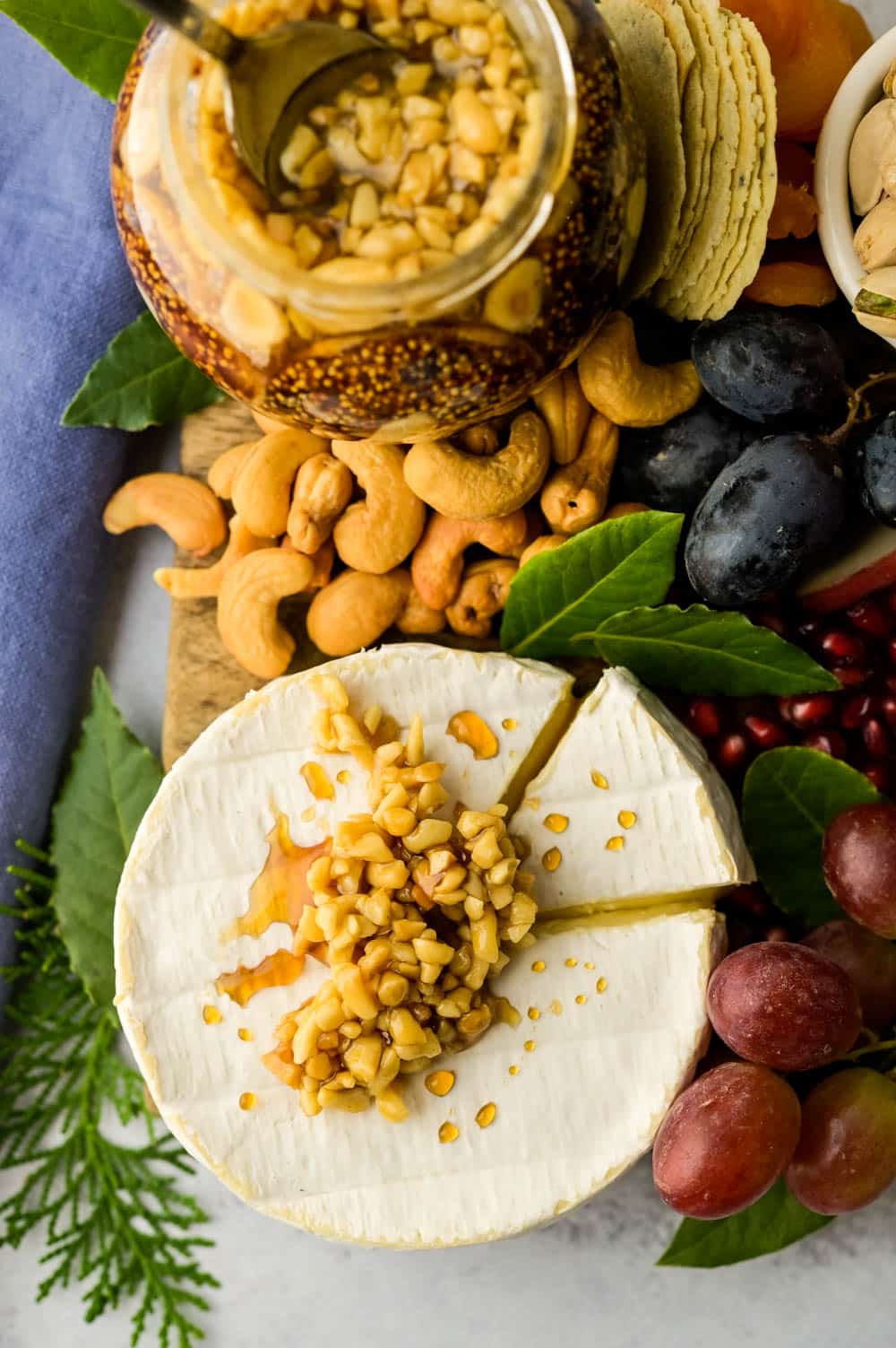 best cheeses for cheese board starts with everyone's favorite brie, topped with honeyed nuts.