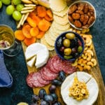 A classic cheese board with olives and nuts.