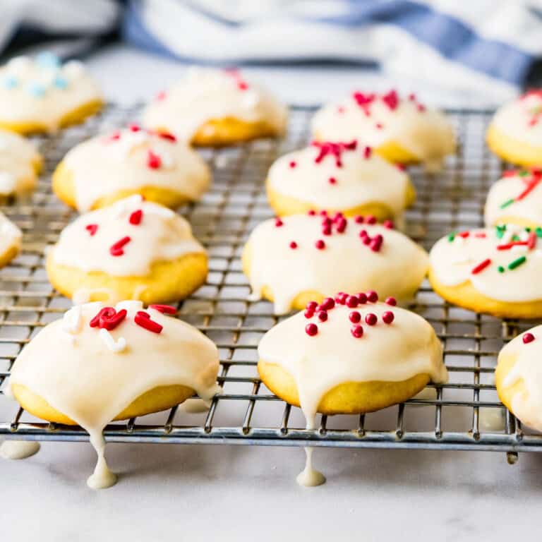 Letting the ricotta cookies dry on a wire rack after decorating with glaze and sprinkles.
