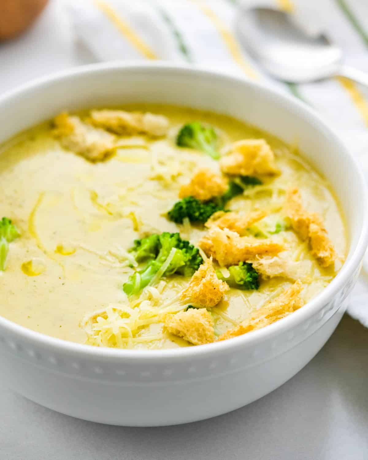 A bowl of broccoli cheese soup with truffled croutons.