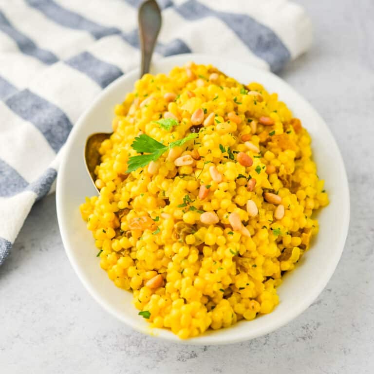 Serving turmeric couscous on a white dish.