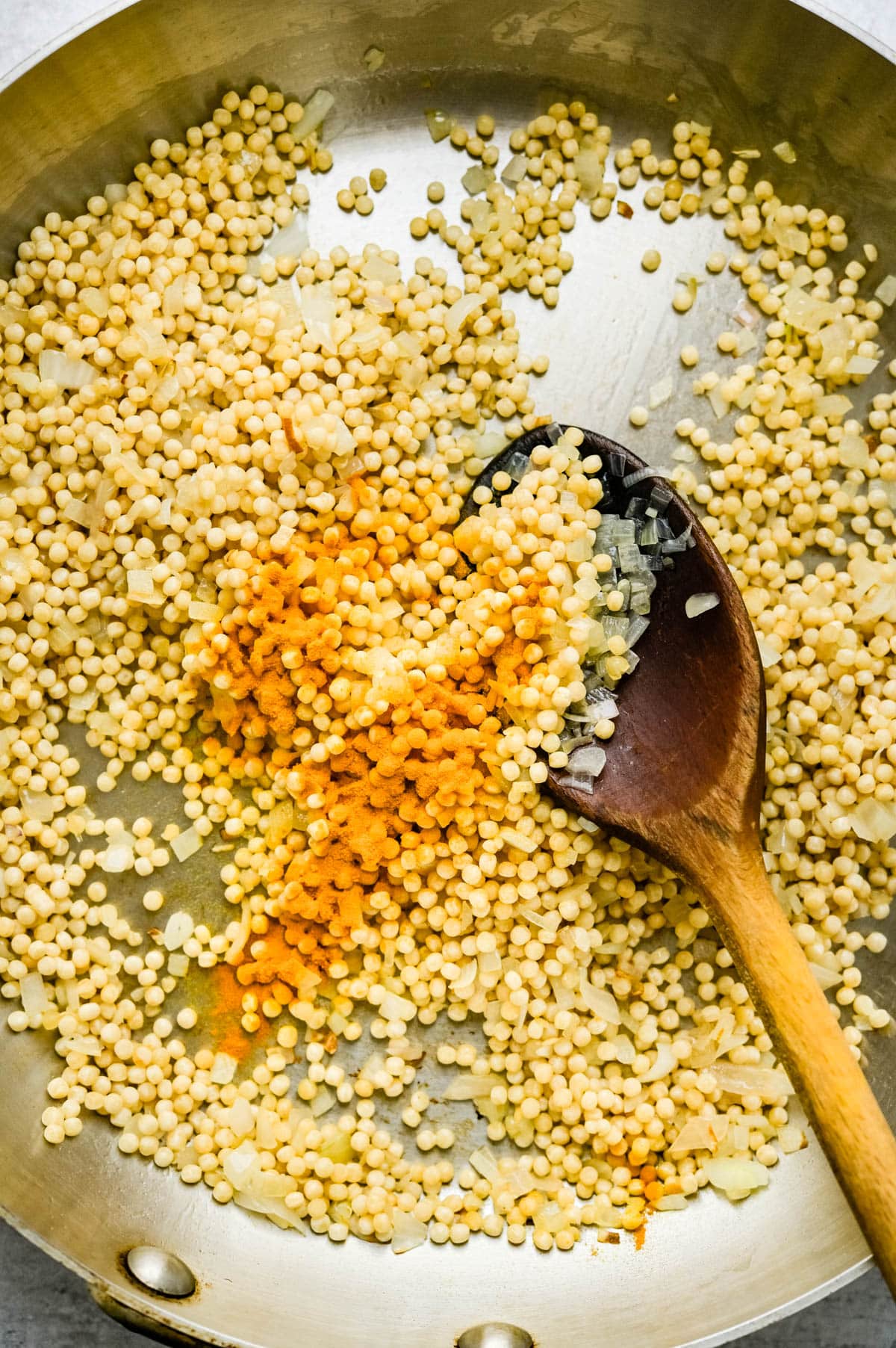 Adding Turmeric to the couscous.