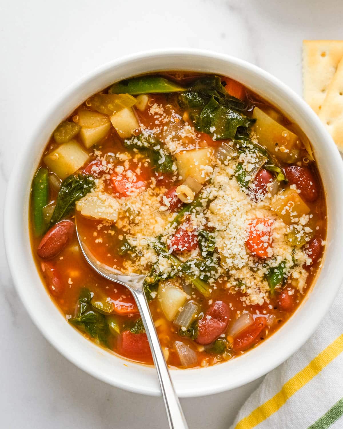 A bowl of minestrone with parmesan cheese.