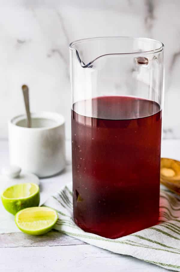 a pitcher of hibiscus tea with lime and sugar.