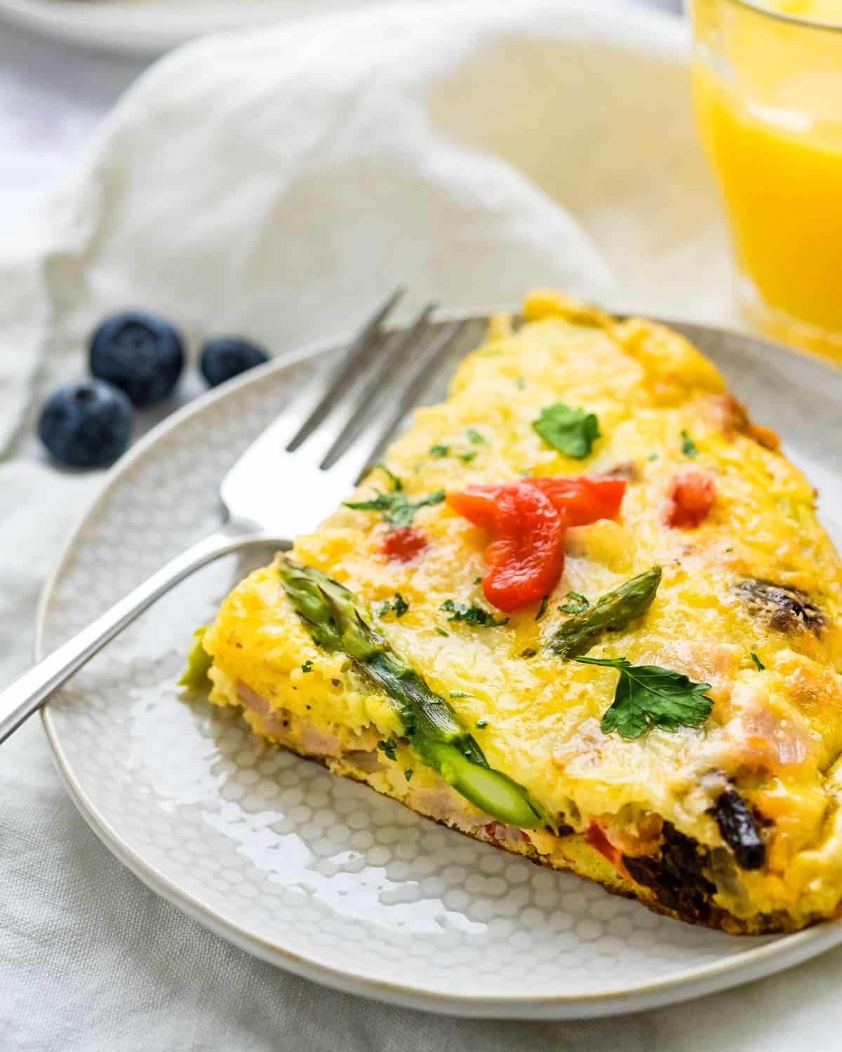 Ham and Cheese Frittata with asparagus on a plate.