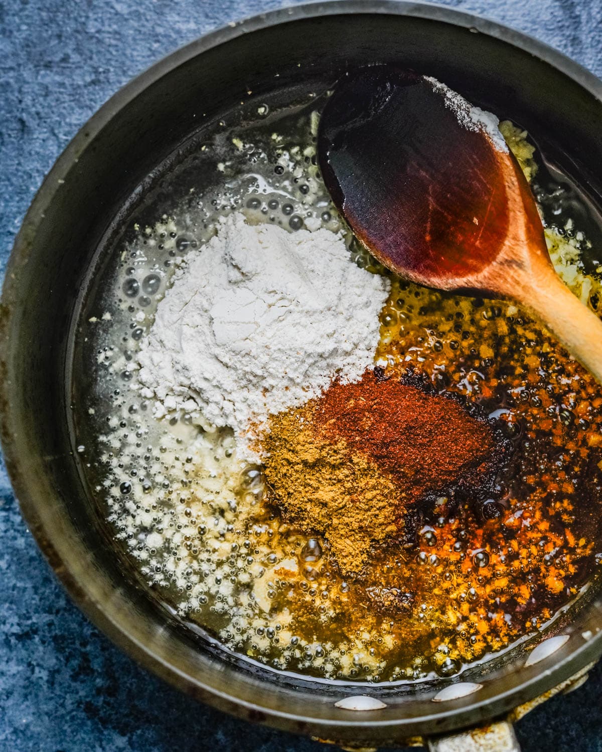 Blooming the spices in hot oil and adding flour.