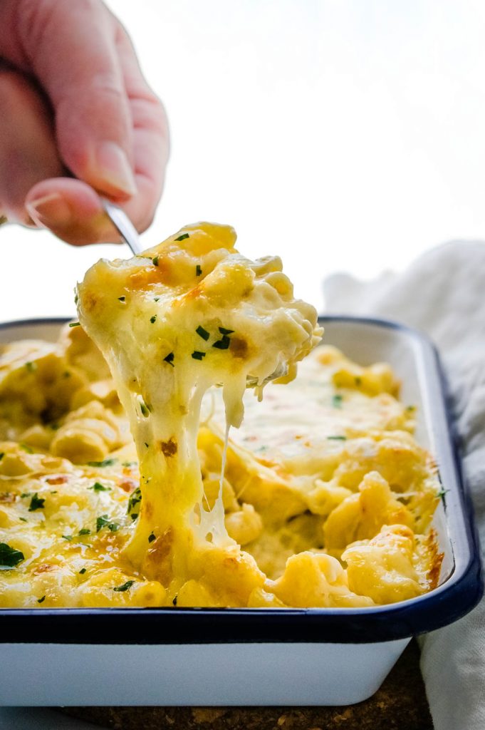 a spoonful of old fashioned mac and cheese with a big "cheese pull".