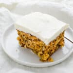 a slice of carrot cake with cream cheese frosting.