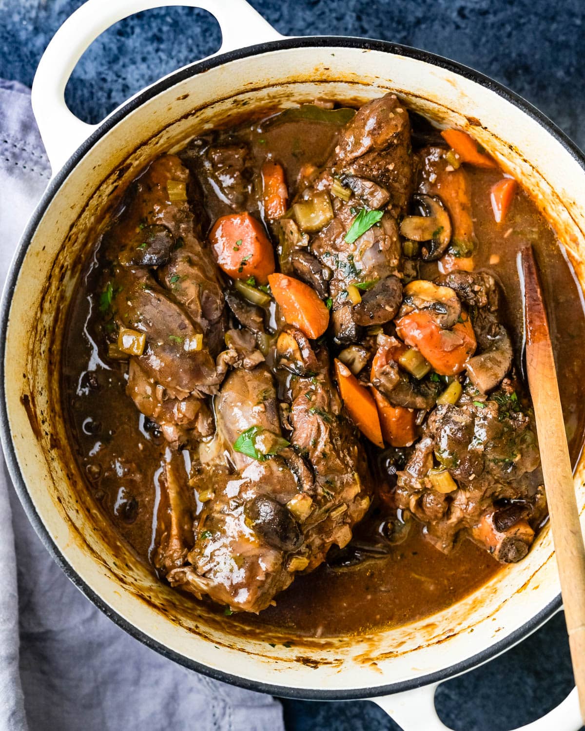 A pot of wine-braised lamb shanks in a Dutch Oven.