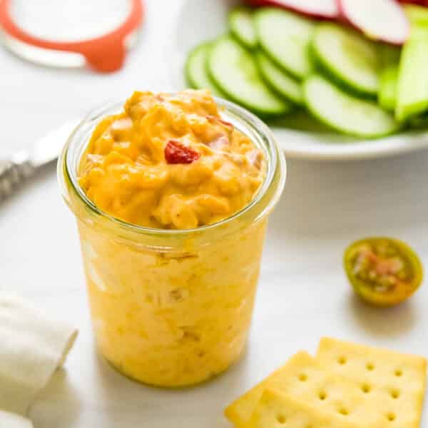 A jar of Southern pimento cheese with crackers and crudites.