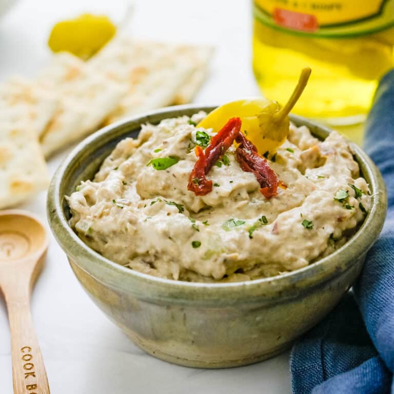 A bowl of whitefish dip with sun dried tomatoes for garnish.