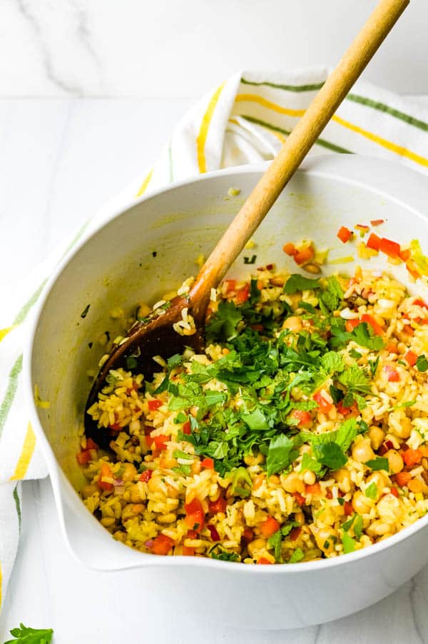 photo of curried rice salad after being mixed in the bowl and adding the fresh torn herbs.