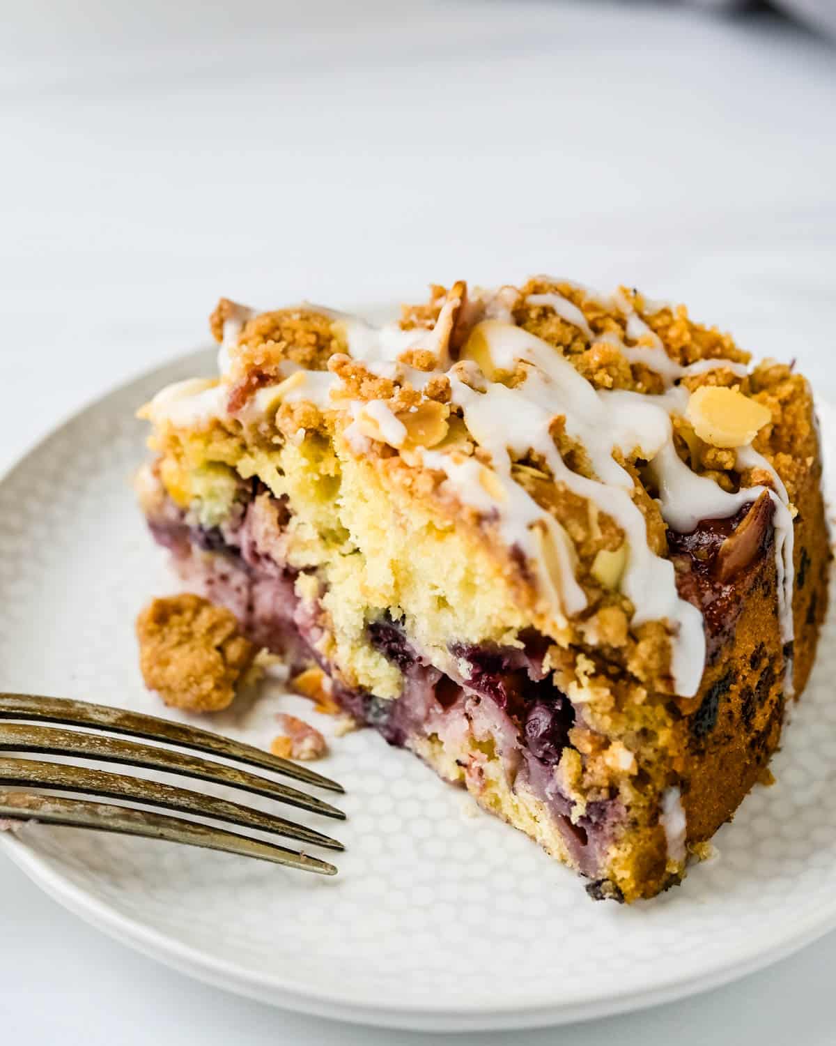 A slice of mixed berry buckle with glaze.