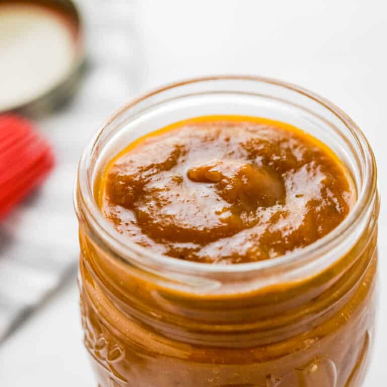 A closeup picture of the thick, sweet and spicy Hawaiian BBQ sauce in a jar.