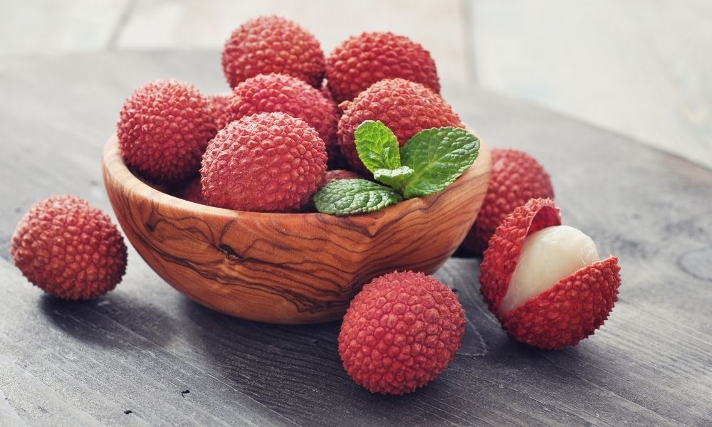 A bowl of lychees in a wooden bowl.