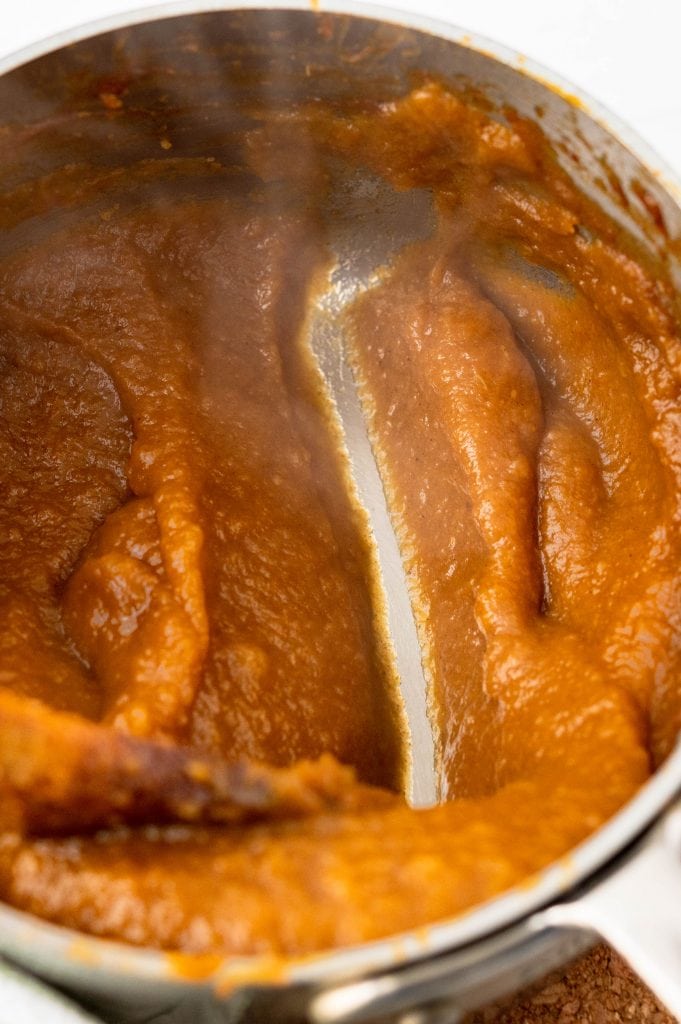 concentrating the pumpkin apple butter puree by simmering in a saucepan.