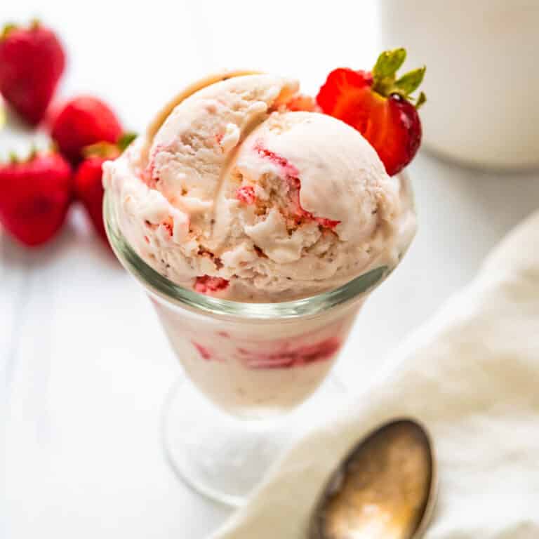 A dish of strawberry ice cream with fresh berries.