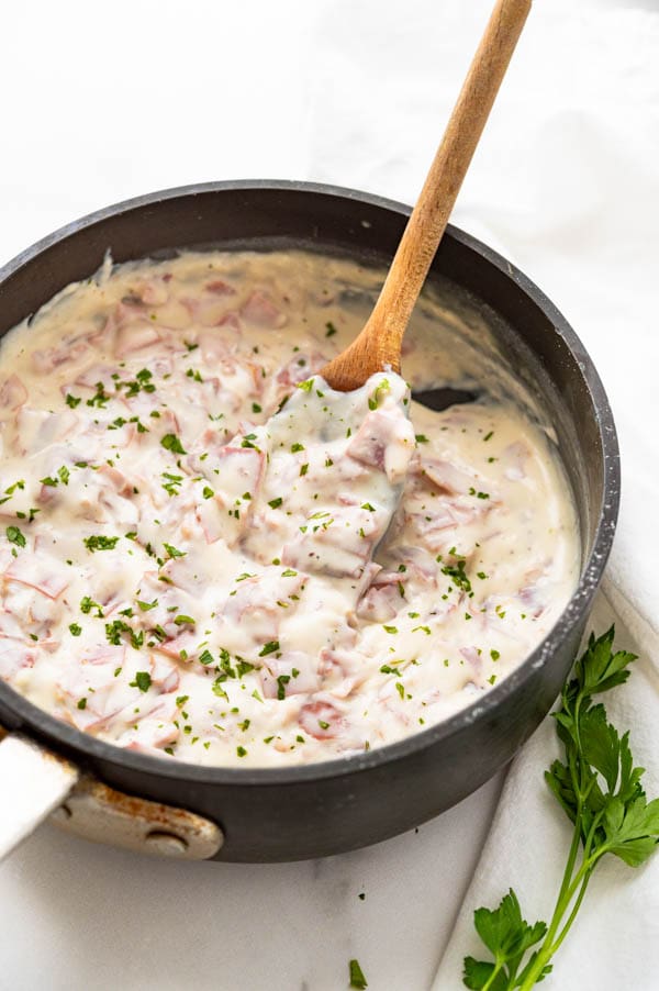 A pan of creamed chipped beef with a little parsley garnish.