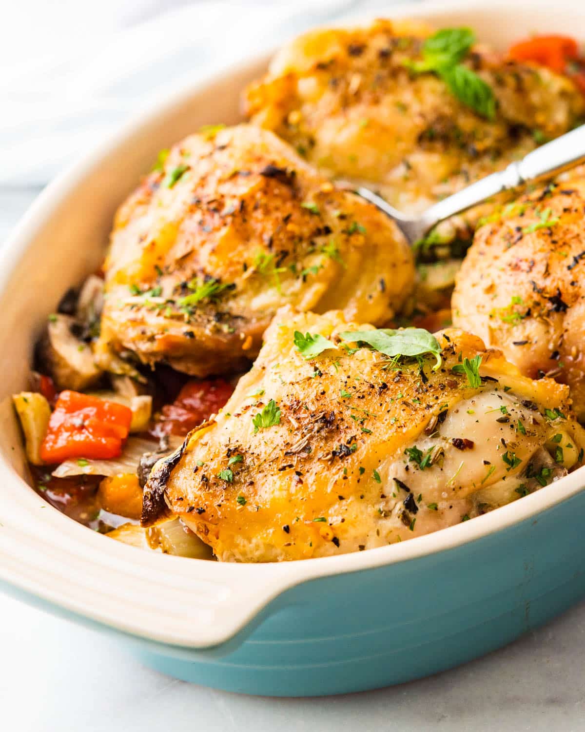Serving baked chicken cacciatore in a baking dish.