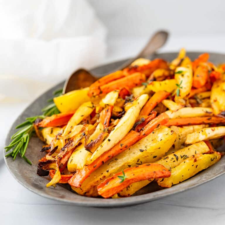 Roasted carrots and parsnips on a pewter serving dish.