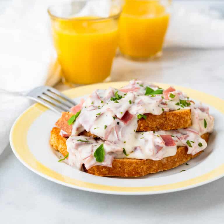 Creamed chipped beef on toast with glasses of orange juice for breakfast.