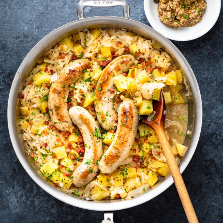 A skillet of choucroute with sausages, sauerkraut, apples and potatoes. Serve with whole-grain mustard.