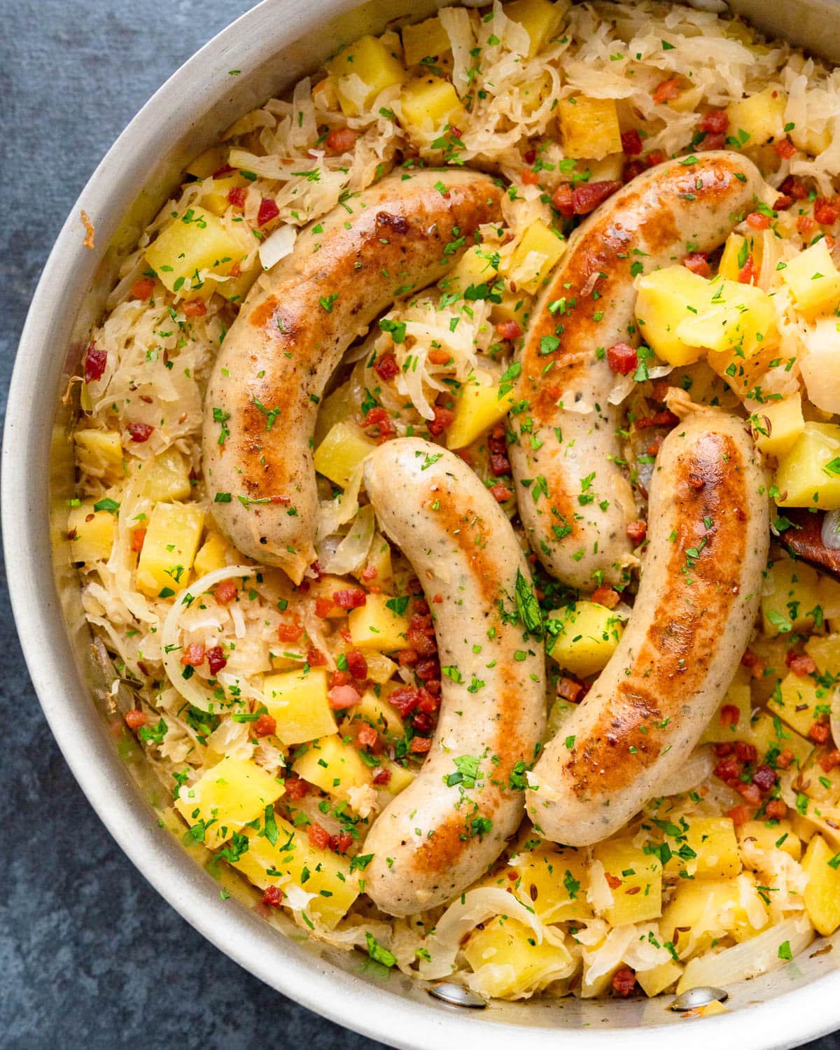 A skillet choucroute with sausage, apples and sauerkraut.
