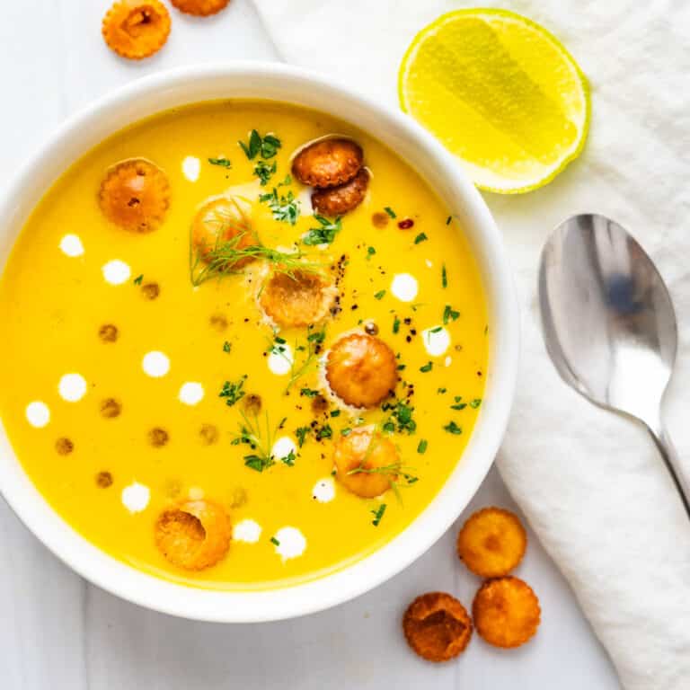 A bowl of curried pumpkin soup with croutons.