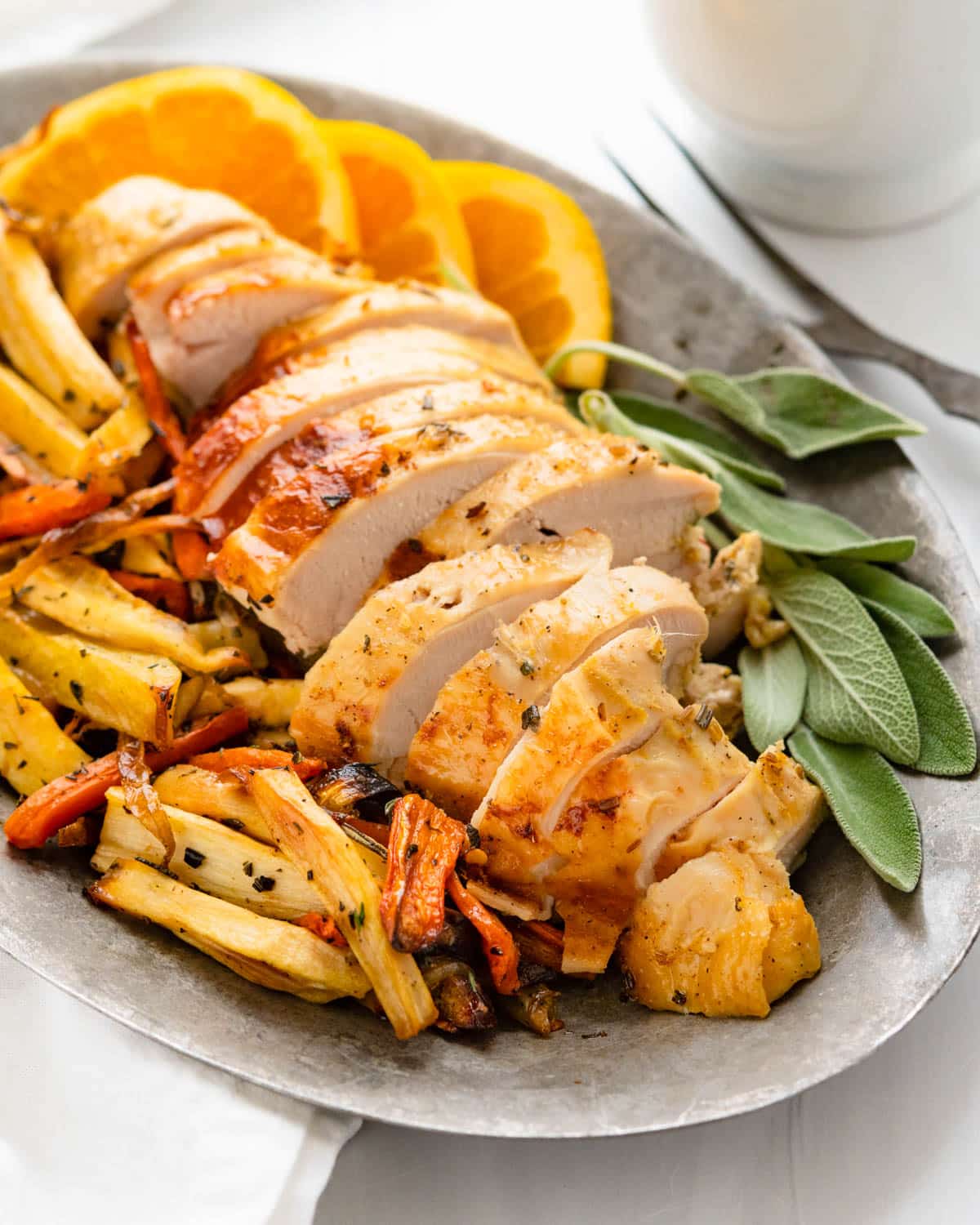 A platter of marinated roast turkey breast with carrots and parsnips.